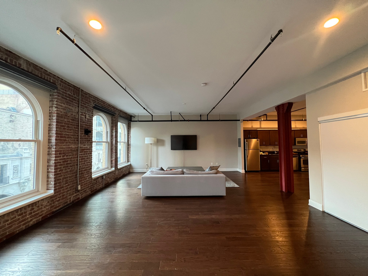 Empty loft with brick walls and arched windows.