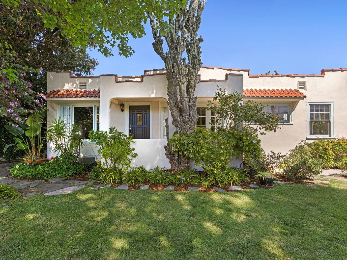 Spanish-style bungalow with established landscaping.